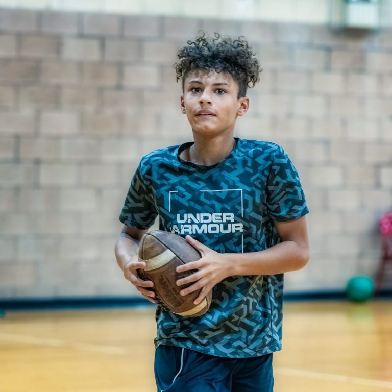 teen boy holding a football