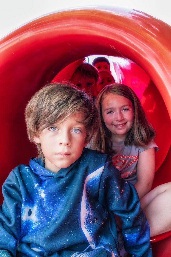 several children sitting in a slide