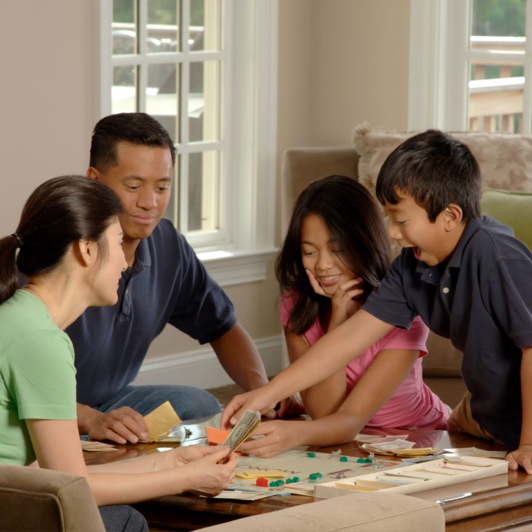 family of four playing a board game